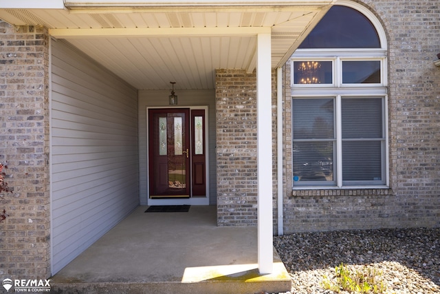 7077 Crosswinds Dr, Swartz Creek, MI 48473 - doorway to property with covered porch and brick siding