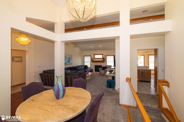 7077 Crosswinds Dr, Swartz Creek, MI 48473 - carpeted dining space featuring a chandelier, baseboards, a high ceiling, and a fireplace