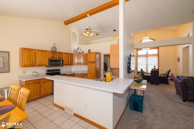7077 Crosswinds Dr, Swartz Creek, MI 48473 - kitchen with brown cabinets, visible vents, stainless steel appliances, light countertops, and high vaulted ceiling