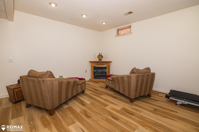 7077 Crosswinds Dr, Swartz Creek, MI 48473 - living room with a glass covered fireplace, visible vents, light wood-type flooring, and baseboards