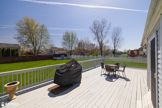 7077 Crosswinds Dr, Swartz Creek, MI 48473 - deck featuring an outdoor structure, a fenced backyard, a storage unit, outdoor dining area, and a lawn