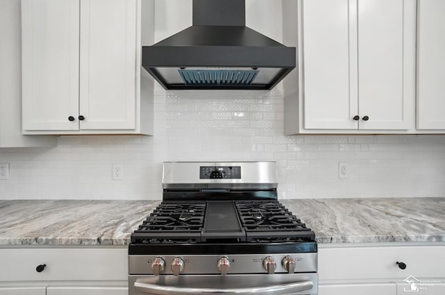 552 Central Park Blvd, Monroe, MI 48162 - kitchen featuring stainless steel gas range oven, wall chimney range hood, white cabinetry, light stone counters, and decorative backsplash