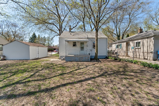 rear view of property featuring fence and an outdoor structure