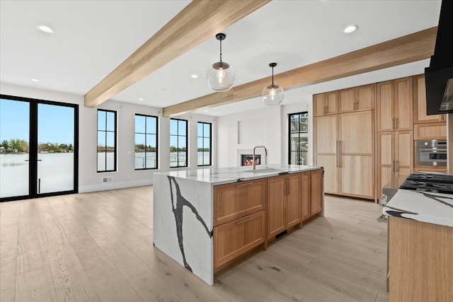 13459 Haddon St, Fenton, MI 48430 - kitchen featuring light stone countertops, beamed ceiling, stainless steel oven, light wood finished floors, and decorative light fixtures