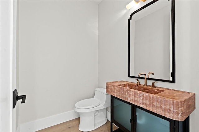 13459 Haddon St, Fenton, MI 48430 - half bathroom featuring a sink, baseboards, toilet, and wood finished floors