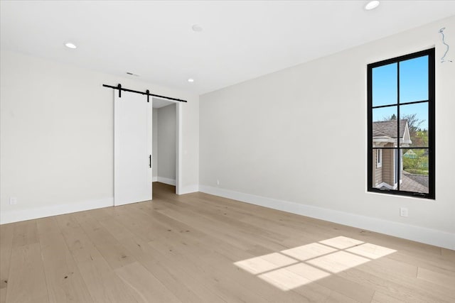 13459 Haddon St, Fenton, MI 48430 - empty room featuring light wood-style floors, baseboards, recessed lighting, and a barn door