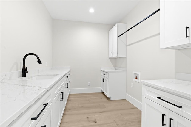 13459 Haddon St, Fenton, MI 48430 - laundry room featuring light wood-style floors, baseboards, hookup for a washing machine, a sink, and cabinet space