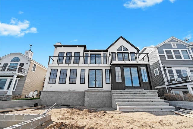 13459 Haddon St, Fenton, MI 48430 - townhome / multi-family property featuring a balcony, entry steps, and stucco siding