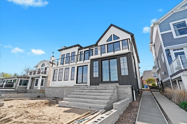 13459 Haddon St, Fenton, MI 48430 - view of front of house with board and batten siding, a balcony, and entry steps