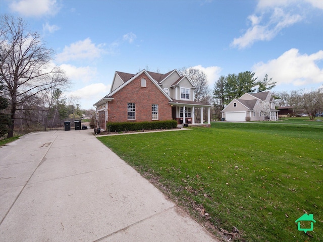 traditional-style home with a front yard, a garage, covered porch, brick siding, and concrete driveway