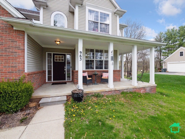 property entrance featuring a yard, a porch, and brick siding