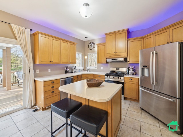 kitchen with light tile patterned floors, stainless steel appliances, light countertops, and under cabinet range hood