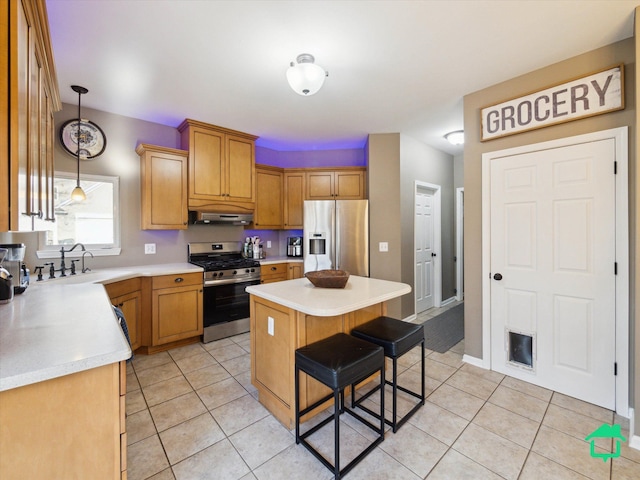 kitchen featuring light countertops, a sink, stainless steel appliances, and under cabinet range hood