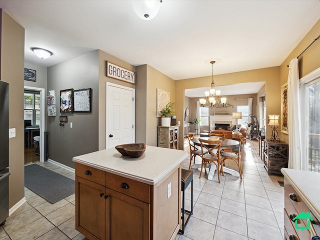 kitchen featuring light tile patterned floors, light countertops, pendant lighting, and a healthy amount of sunlight