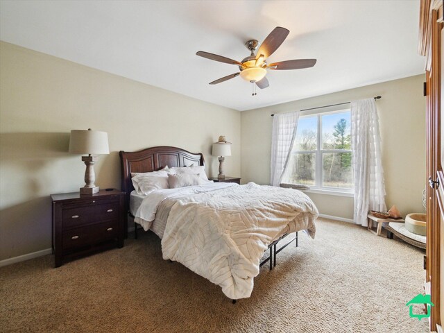 carpeted bedroom featuring ceiling fan and baseboards