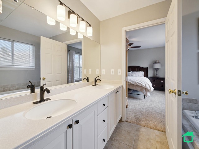 ensuite bathroom featuring double vanity, connected bathroom, tile patterned flooring, and a sink