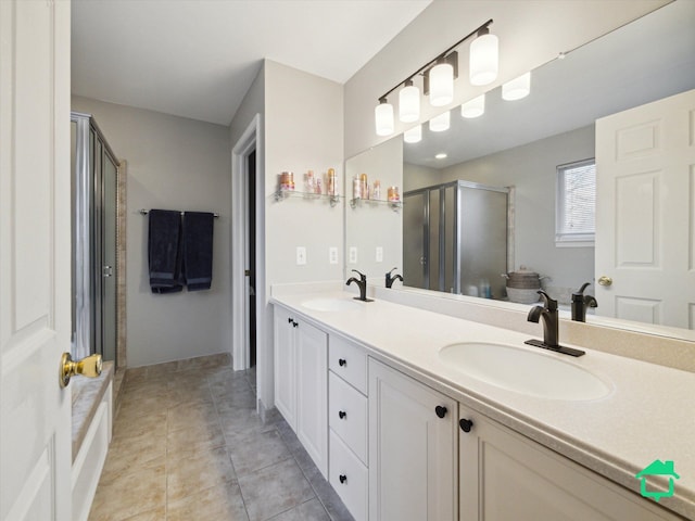 bathroom featuring a stall shower, double vanity, a sink, and tile patterned floors