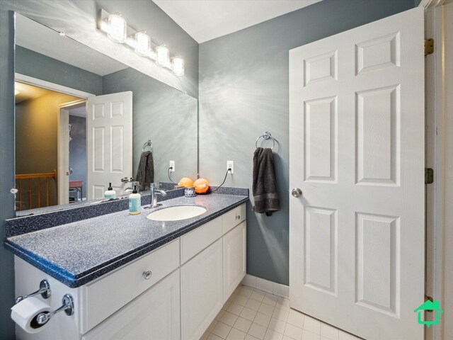 bathroom with tile patterned floors, baseboards, and vanity