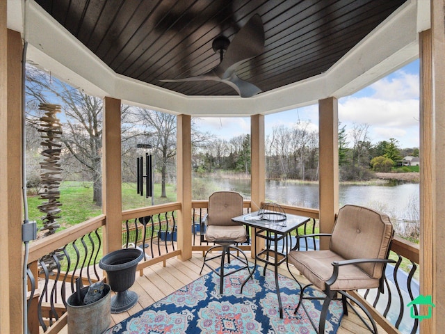 wooden deck with a ceiling fan and a water view