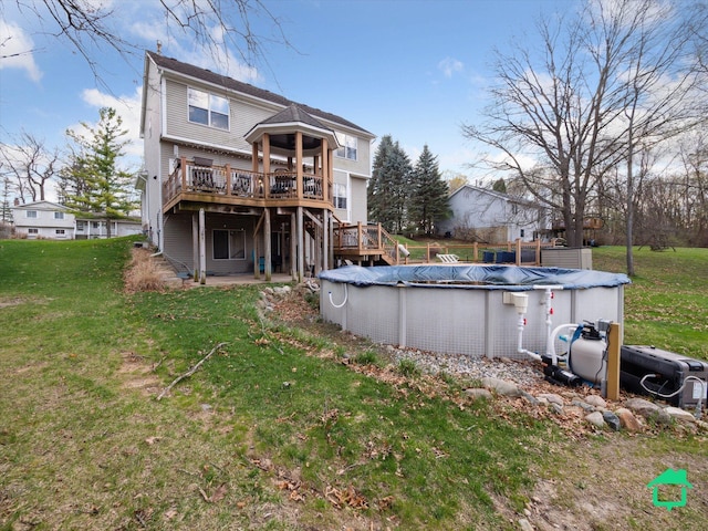 back of property with a deck, a yard, and a covered pool