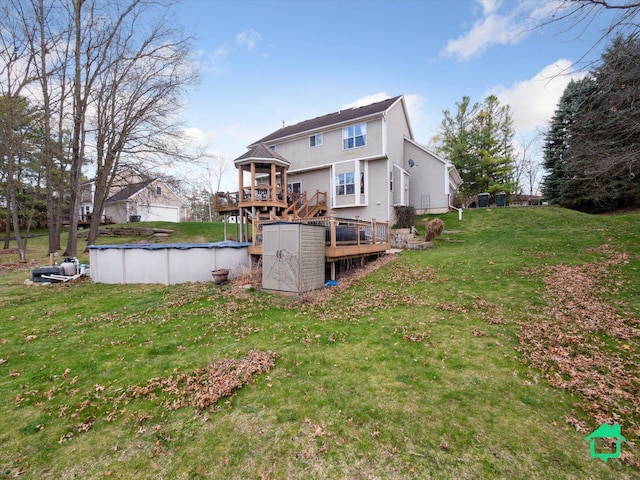back of house featuring a lawn, a deck, and a covered pool