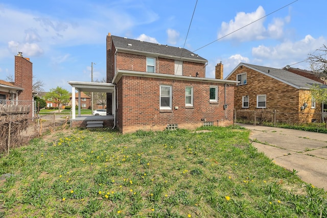 8790 E Outer Dr, Detroit, MI 48213 - rear view of house with brick siding, fence, and a lawn