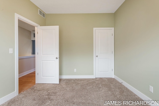 unfurnished bedroom with baseboards, visible vents, and carpet floors