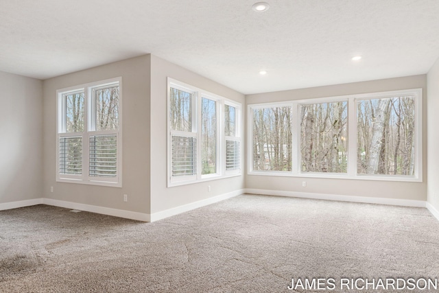 carpeted spare room featuring recessed lighting and baseboards