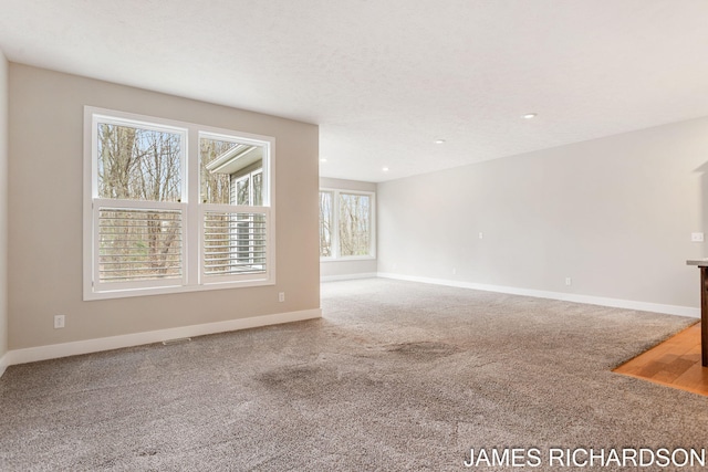 unfurnished living room with carpet, recessed lighting, and baseboards