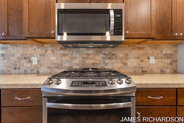 kitchen with brown cabinets, stainless steel appliances, light countertops, and backsplash