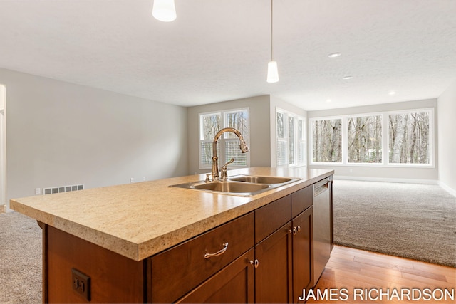 kitchen featuring recessed lighting, stainless steel dishwasher, a sink, visible vents, and open floor plan