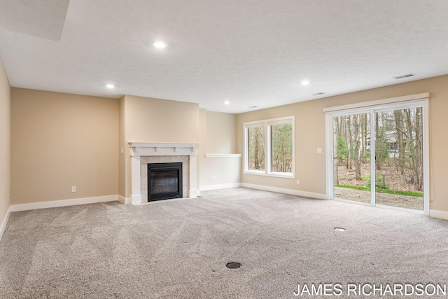 unfurnished living room featuring recessed lighting, a fireplace, carpet flooring, baseboards, and visible vents