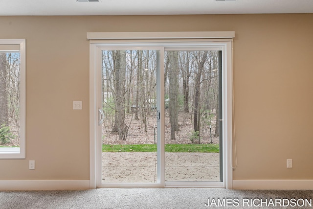 doorway to outside featuring carpet flooring, a wealth of natural light, and visible vents