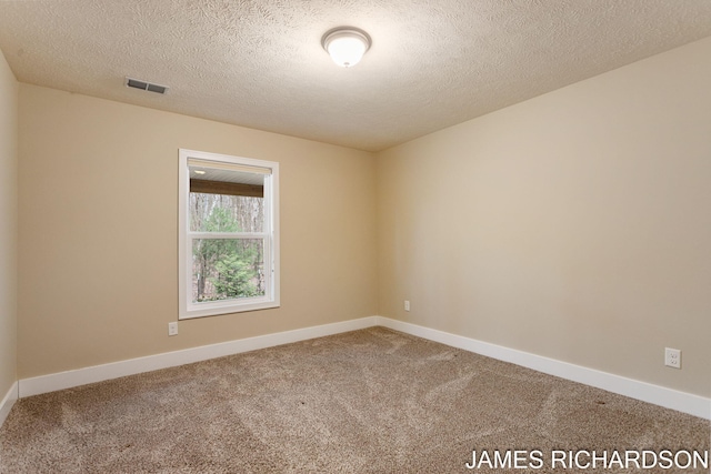 carpeted empty room with a textured ceiling, visible vents, and baseboards