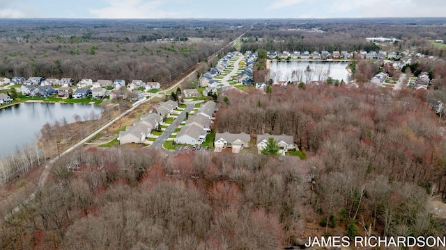 birds eye view of property featuring a residential view, a water view, and a view of trees