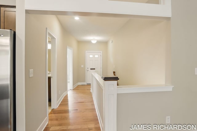 corridor with baseboards, recessed lighting, and light wood-style floors