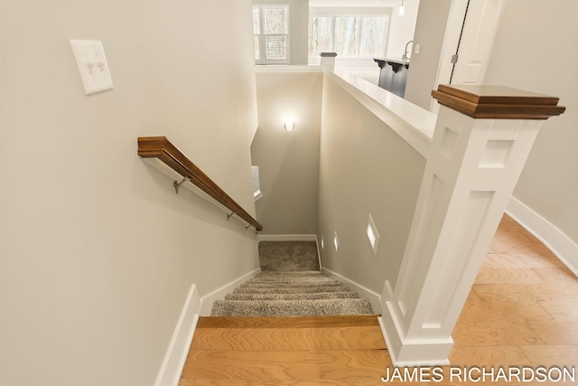stairs with wood finished floors and baseboards