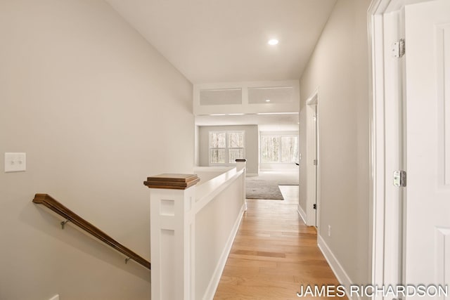 hallway with light wood-style floors, recessed lighting, an upstairs landing, and baseboards