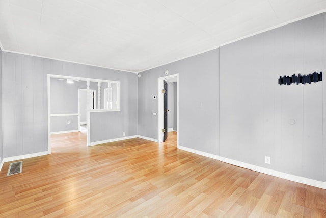 spare room with light wood-style floors, baseboards, and crown molding