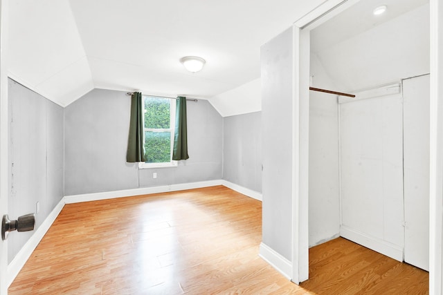 bonus room with vaulted ceiling, wood finished floors, and baseboards