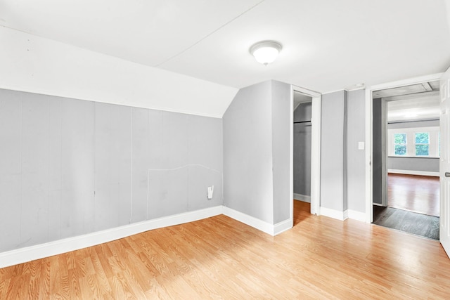 bonus room featuring wood finished floors, baseboards, and vaulted ceiling