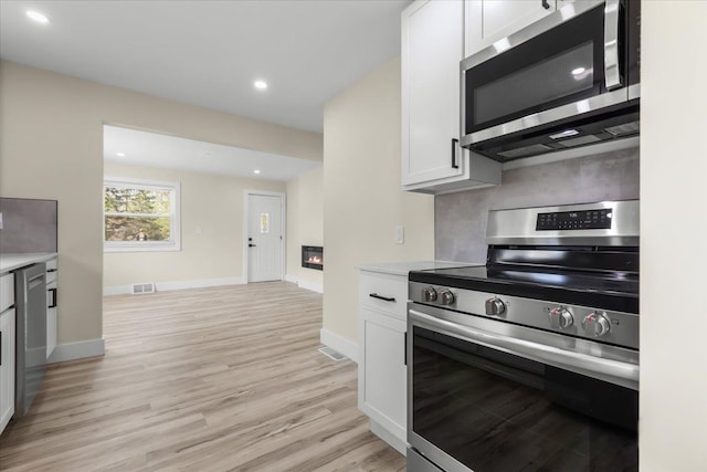 kitchen with light wood-style floors, light countertops, visible vents, and stainless steel appliances