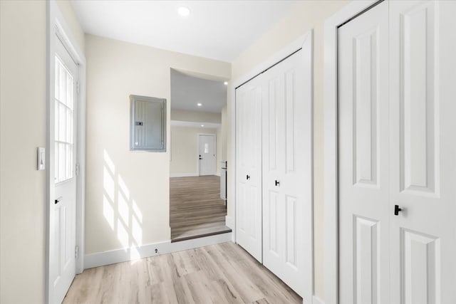 interior space with light wood-type flooring, recessed lighting, baseboards, and electric panel