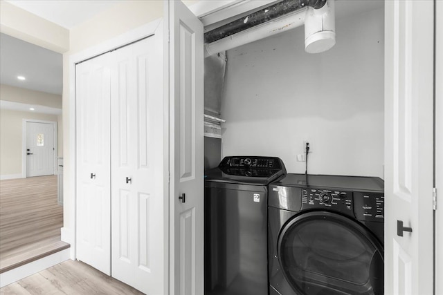 washroom featuring separate washer and dryer, laundry area, recessed lighting, and wood finished floors