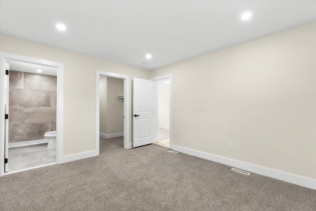 unfurnished bedroom with baseboards, recessed lighting, carpet floors, and a spacious closet