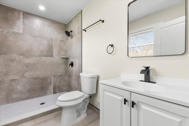 full bath with vanity, toilet, and tiled shower
