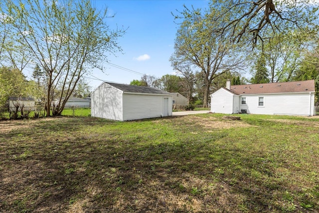 view of yard featuring fence and an outbuilding