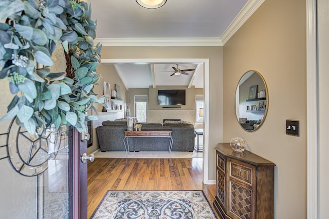 entrance foyer with crown molding, ceiling fan, baseboards, wood finished floors, and beamed ceiling