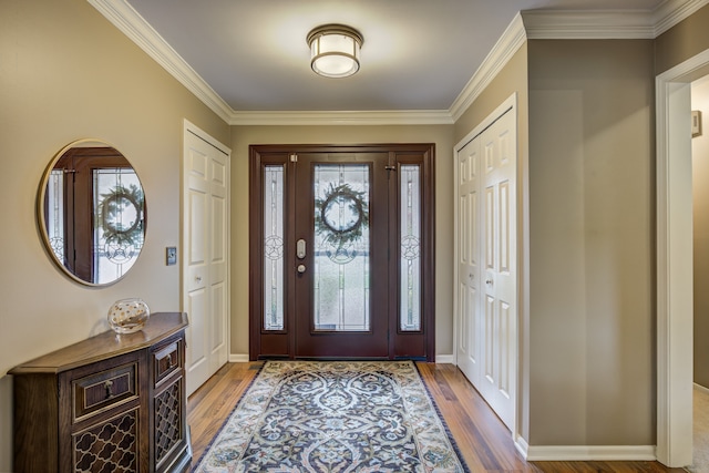 entryway with baseboards, ornamental molding, and wood finished floors