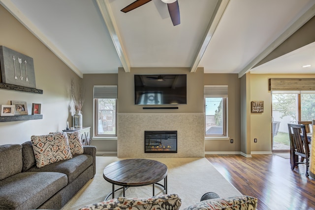 living room with a healthy amount of sunlight, baseboards, a ceiling fan, and wood finished floors
